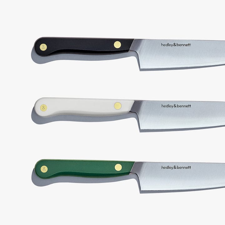 Three utility knives shown together in black, white, and green handles