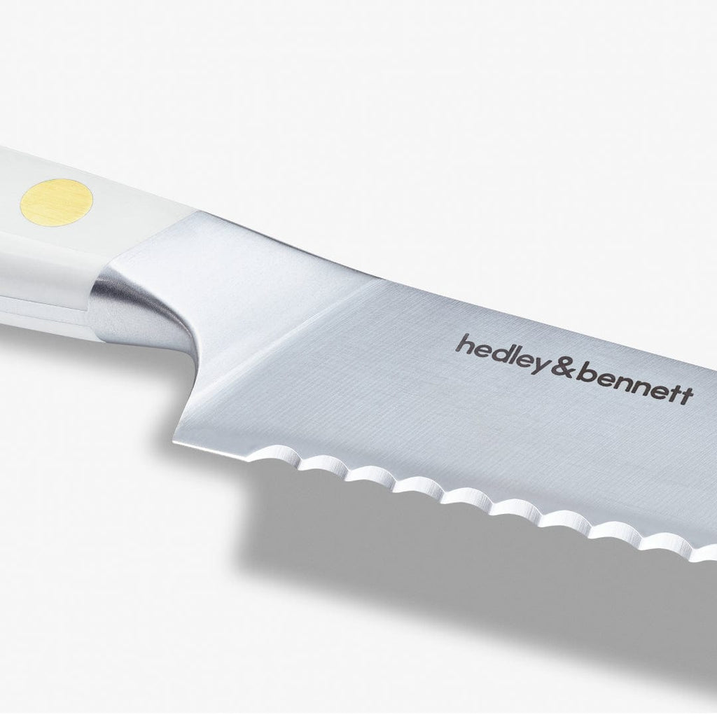 Close-up of the bread knife's serrated edge and the maker's mark on the blade