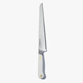 Serrated bread knife with a white handle and brass pin, standing upright