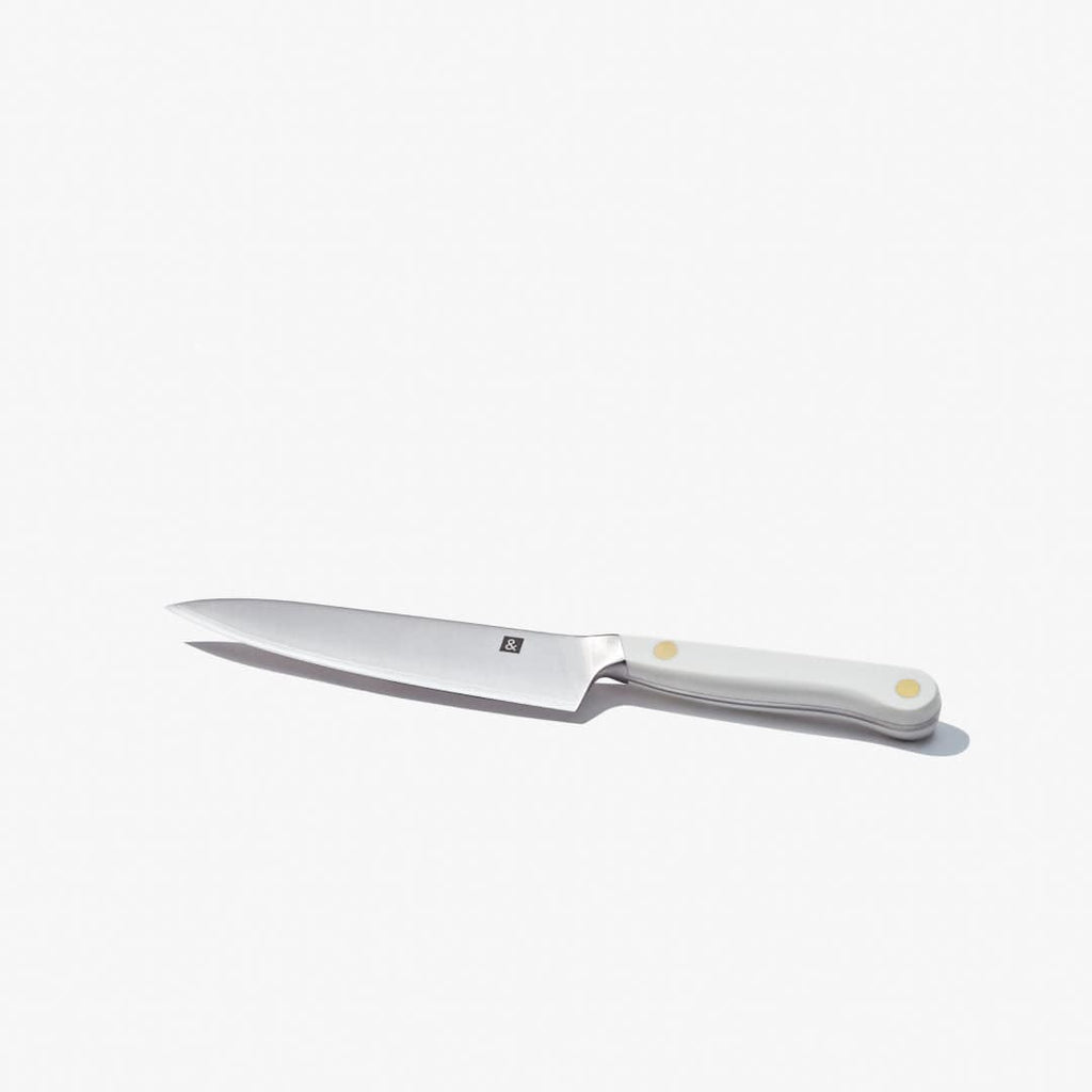 Utility knife laid flat, showing the full blade and white handle