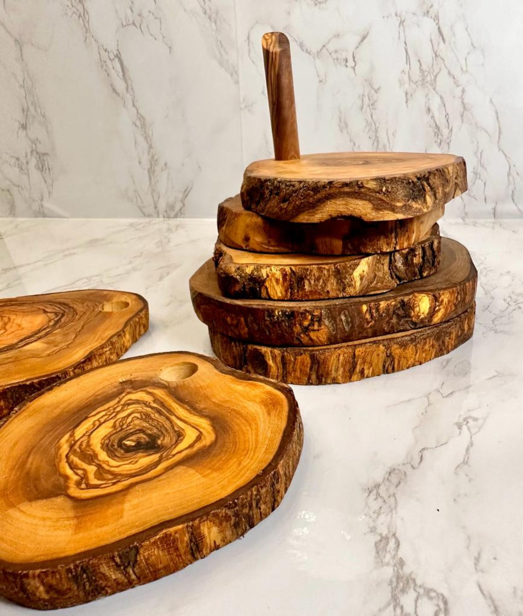 Stack of live-edge olive wood coasters on a marble surface