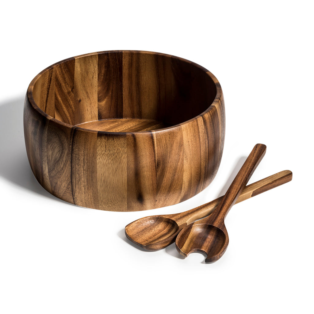 Extra-large acacia salad bowl with matching wooden servers laid beside it